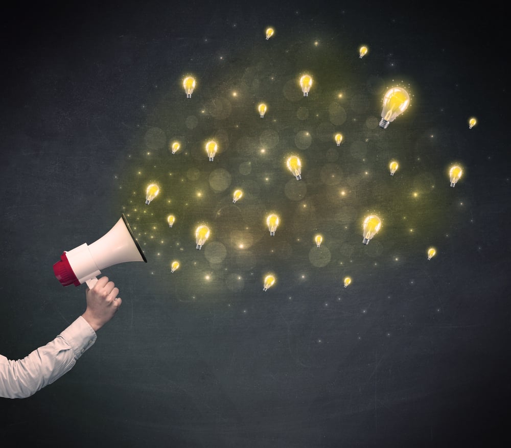 Caucasian business hand holding megaphone with yellow lightbulbs