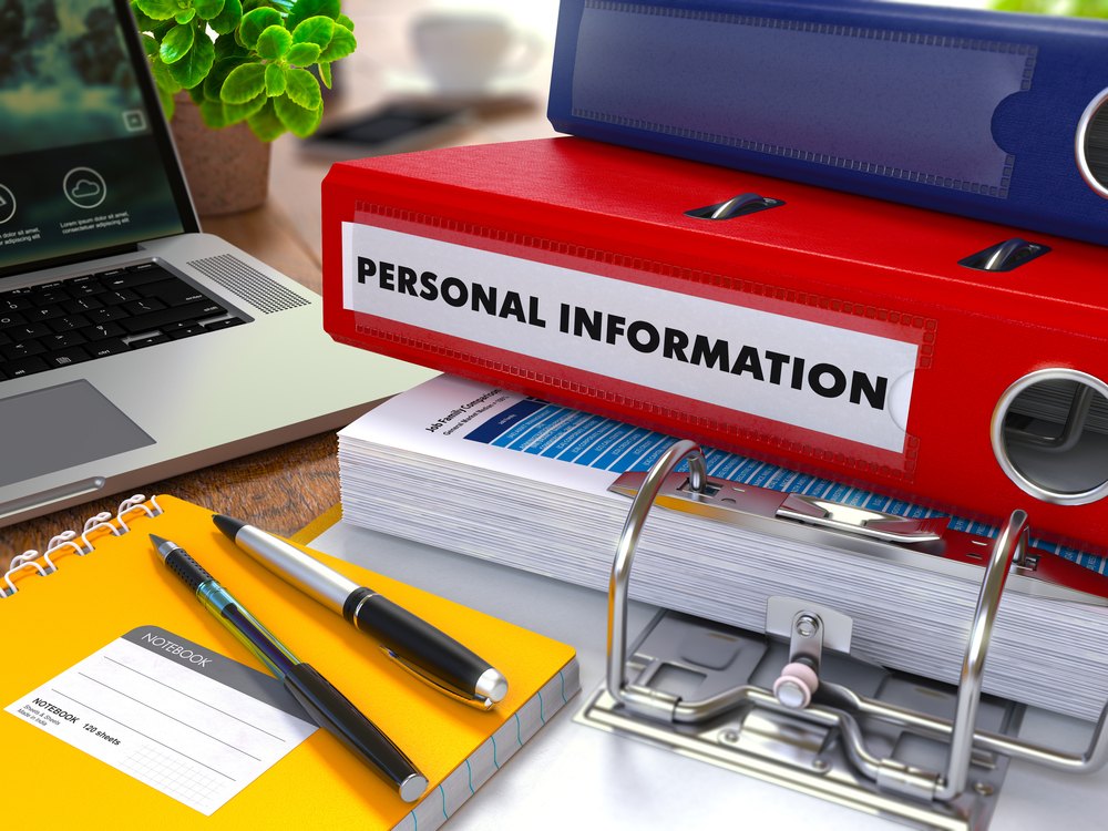 Red Ring Binder with Inscription Personal Information on Background of Working Table with Office Supplies, Laptop, Reports. Toned Illustration. Business Concept on Blurred Background.